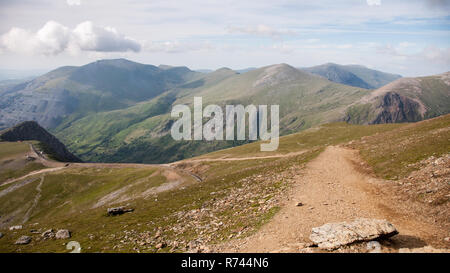 Ein Zug steigt vom Gipfel des Snowdon Mountain auf der Schmalspur rack Bergbahn mit dem Llanberis Tal und Halden der Dinorwig s Stockfoto