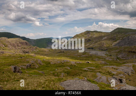 Verlassene und verfallene Schieferabbau Gebäude stehen inmitten von Geröll Tipps und die moelwyn Berge im Tal über Cwmorthin Blaenau Ffestiniog in Sn Stockfoto