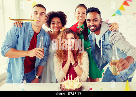 Glückliche Mitarbeiter mit Kuchen im Büro Geburtstag party Stockfoto