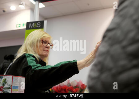 Eine ältere Arbeiterin, die an einer Kasse arbeitet Kasse im M&S Marks und Spencer Lebensmittelgeschäft In Großbritannien UK KATHY DEWITT Stockfoto