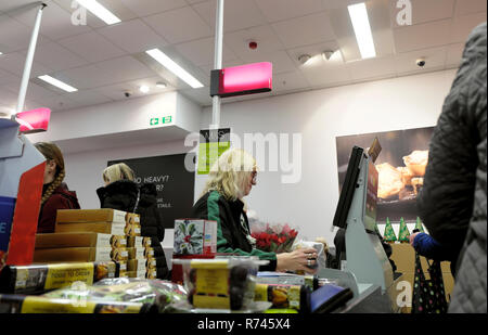 Eine ältere Arbeitnehmerin der Arbeit an der Kasse im M & S Marks und Spencer food Grocery Store in Großbritannien Großbritannien. KATHY DEWITT Stockfoto