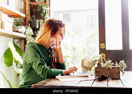 Junge Frau mit Laptop im café Stockfoto