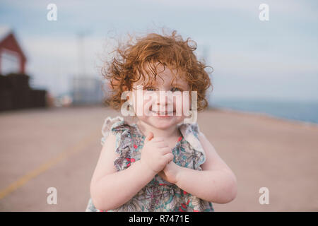 Mädchen mit lockigem Haar an der Küste, Porträt Stockfoto