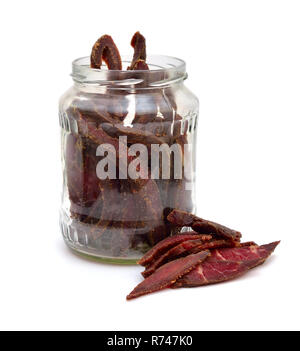 Beef Jerky in einem Glas auf weißem Hintergrund. Stockfoto