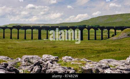 Ribblehead, England, Großbritannien - 3. Juli 2015: ein Zug von Frachtcontainern kreuzt die Ribblehead Viadukt auf der malerischen Vereinbaren und Carlisle Railway in Engl Stockfoto