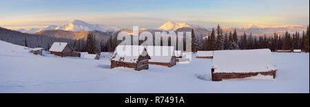 Panorama Mountain Village der Hirten. Winterlandschaft mit Holzhäusern. Schöne Dämmerung frostigen Morgen. Karpaten, Ukraine Stockfoto