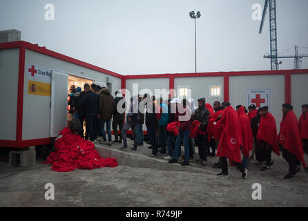 Migrantinnen und Migranten sind zu sehen, die in der Warteschlange zum Eingeben einer humanitären Notsituation Stall nach Ihrer Ankunft im Hafen von Malaga warten. Spaniens Maritime Rescue Service gerettet Über 148 Migranten an Bord Jollen auf der Alboran See, und brachte sie nach Malaga Hafen, von wo aus sie durch das Spanische Rote Kreuz unterstützt wurden. Stockfoto
