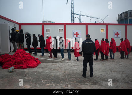 Migrantinnen und Migranten sind zu sehen, die in der Warteschlange zum Eingeben einer humanitären Notsituation Stall nach Ihrer Ankunft im Hafen von Malaga warten. Spaniens Maritime Rescue Service gerettet Über 148 Migranten an Bord Jollen auf der Alboran See, und brachte sie nach Malaga Hafen, von wo aus sie durch das Spanische Rote Kreuz unterstützt wurden. Stockfoto
