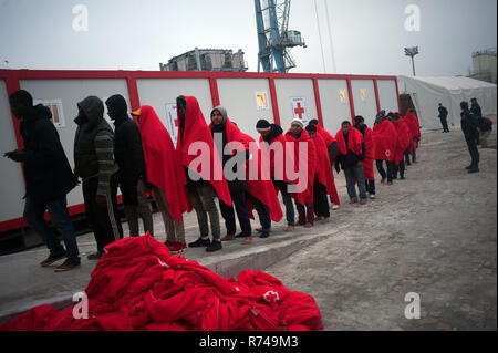 Migrantinnen und Migranten sind zu sehen, die in der Warteschlange zum Eingeben einer humanitären Notsituation Stall nach Ihrer Ankunft im Hafen von Malaga warten. Spaniens Maritime Rescue Service gerettet Über 148 Migranten an Bord Jollen auf der Alboran See, und brachte sie nach Malaga Hafen, von wo aus sie durch das Spanische Rote Kreuz unterstützt wurden. Stockfoto