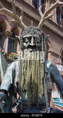 Ein riesiges Gesicht der Grüne Mann ist einer der vielen Daemon wie Zahlen, die Parade durch die Stadt ein, in der sich das England von Chester im Laufe der Jahrhunderte alten Hochsommer Watch Festival. Stockfoto