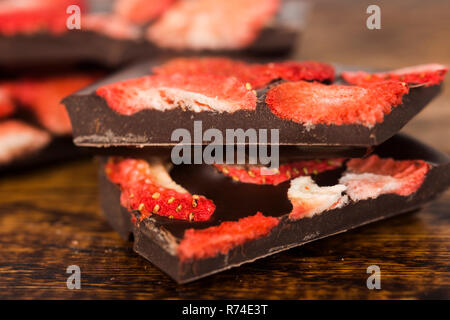 Stapel von Schokolade Scheiben mit Erdbeere auf hölzernen Hintergrund Stockfoto