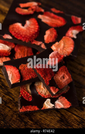 Stapel von Schokolade Scheiben mit Erdbeere auf hölzernen Hintergrund Stockfoto