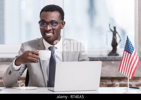 Afrikanische amerikanische Geschäftsmann holding Schale mit Getränk in modernen Büro Stockfoto