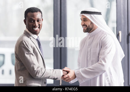 In der Nähe der afrikanischen amerikanischen Geschäftsmann und arabischer Partner die Hände schütteln im Büro Stockfoto