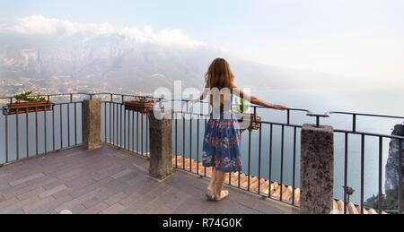 Mädchen stehen auf dem berühmten Terrasse in einem kleinen Ort in Tremosine im Morgengrauen. Italien. Stockfoto