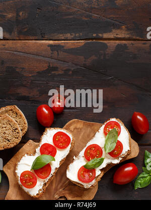 Bruschetta mit Frischkäse, Cherry Tomaten und Basilikum Stockfoto