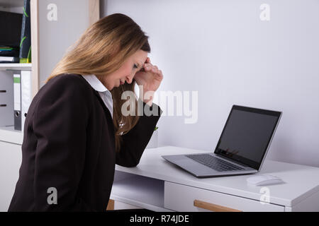 Seitenansicht eines Geschäftsfrau leiden unter Kopfschmerzen. Stockfoto
