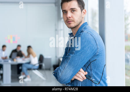 Lächelnd Geschäftsmann in Jeanshemd mit Kamera im Büro Stockfoto