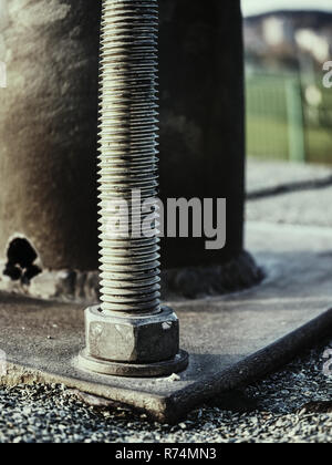 Schrauben Basis wählen Sie konzentrieren. Brückenstütze verankern. Steel Joint von Girder Bridge mit Betonsockel im Boden Stockfoto