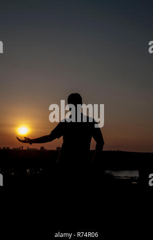 Mann hält die Sonne über Belgrad Stockfoto