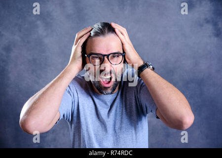 Mann geschockt und seinen Kopf Holding Stockfoto