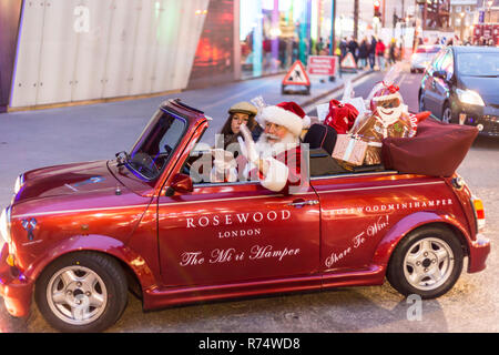 LONDON, Vereinigtes Königreich - 3. Dezember 2015 - Weihnachtsmann liefern präsentiert Leute auf der Straße mit dem Auto. Moderne Santa-Konzept Stockfoto
