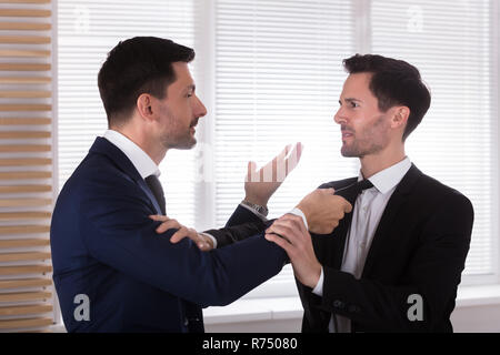 Wütend Geschäftsmann Holding seines Partners Binden Stockfoto