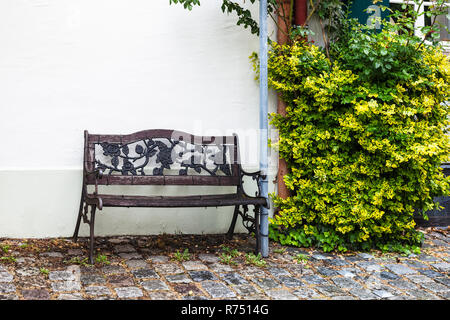 Nasse alte Sitzbank im regnerischen Frühlingstag Stockfoto