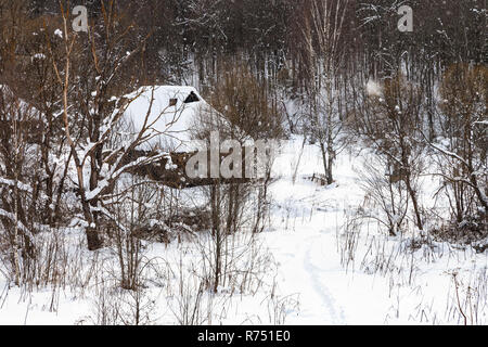 Alte Holzhäuser am Waldrand im Winter Stockfoto