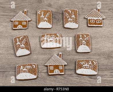 Gruppe von reich verzierten Weihnachten Lebkuchen auf Holz Hintergrund. Schöne verzierte Lebkuchen Spezialitäten im Haus Form und mit handbemalten Kapelle im Schnee. Stockfoto