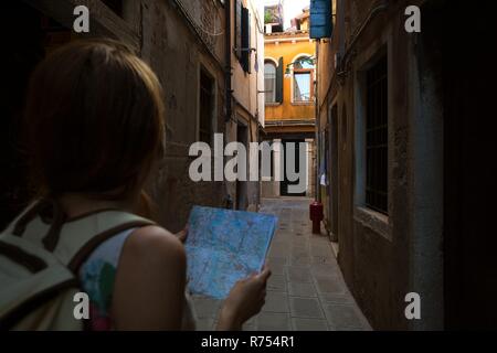 Reisende Mädchen schaut auf die Karte von Walking in Venedig, Italien Stockfoto