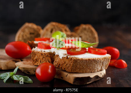 Bruschetta mit Frischkäse, Cherry Tomaten und Basilikum Stockfoto