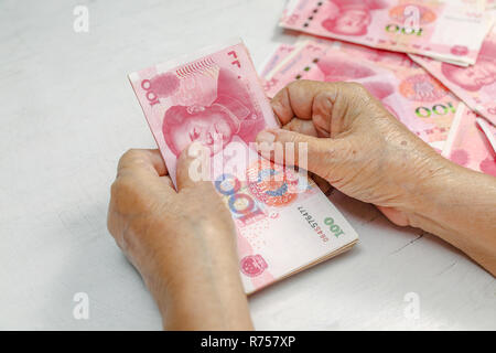 Chinesische Senior Frau zählen Geld für Zahlung Stockfoto