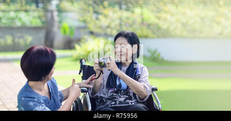 Tochter auf der Suche nach ältere Mutter im Hinterhof Stockfoto