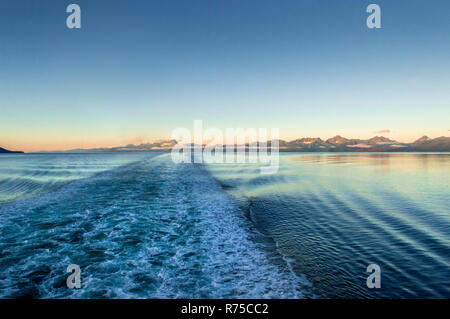 Das Schiff ocean Wake in der Dämmerung mit sunrise Licht auf die schroffen Berge über Ozean Kanal. Blickrichtung Südwest, in der Nähe von Stephen's Passage, Alaska, USA. Stockfoto