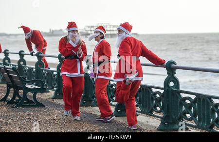 Brighton, Sussex, UK. 08. Dezember 2018. Hunderte Weihnachtsmänner nehmen an den jährlichen Brighton Santa Strich entlang der Küste von Hove, Geld für die lokale Rockinghorse Nächstenliebe. Rockinghorse ist ein Brighton-basierte Nächstenliebe, unterstützt Kinder in Sussex seit über 50 Jahren. Foto: Simon Dack/Alamy leben Nachrichten Stockfoto