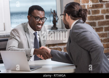 Lächelnd afrikanische amerikanische Geschäftsmann und Business Partner die Hände schütteln im Büro Stockfoto