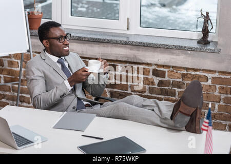 Afrikanische amerikanische Geschäftsmann mit Kaffee Tasse Füße herauf im Büro Stockfoto