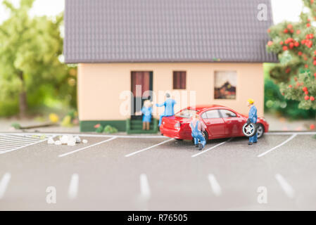 Miniatur Mechanik Austausch einer defekten Reifen weg von der Fahrbahn Stockfoto