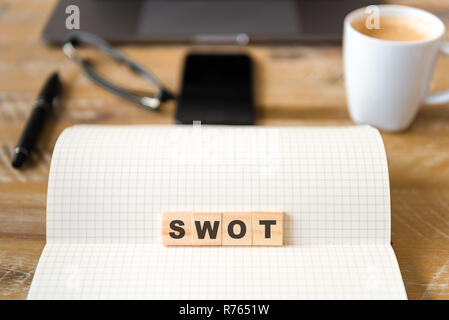 Nahaufnahme auf das Notebook um Holz Tisch Hintergrund, auf Holzblöcken mit Buchstaben, SWOT-Analyse Text konzentrieren Stockfoto