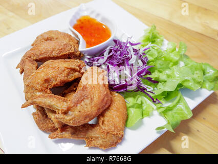 Fried Chicken Wing/batter Fried Chicken crispy auf weiße Platte und Salat Salat lila Kohl Gemüse und Chili pikanter Sauce - Fried Chicken Wing Stockfoto