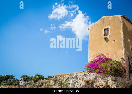 Sizilien, Italien. Altes Haus mit lila Blüten in Syrakus. Stockfoto