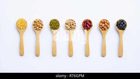 Verschiedene Arten von Leguminosen auf Holzlöffel, weisser Hintergrund. Stockfoto