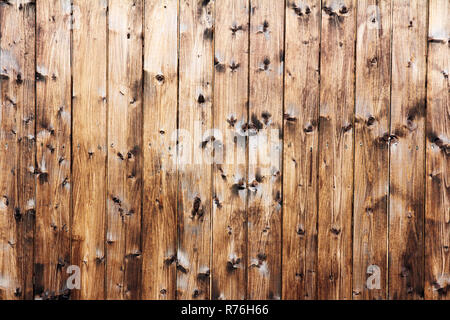 Eine braune hölzerne Wand mit vielen Astansätze. Holz- Textur einer Holzwand Stockfoto