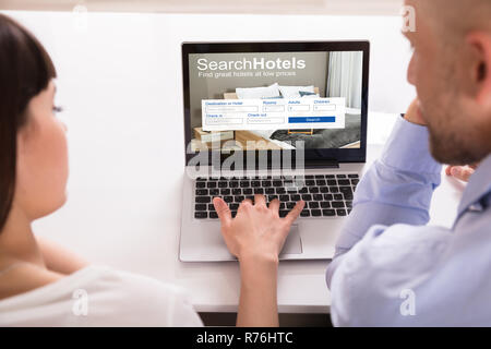 Paar Suche Online Hotels auf Laptop Stockfoto