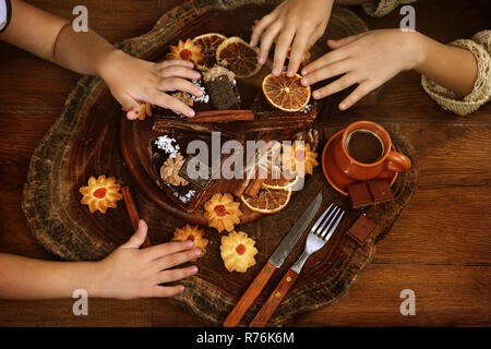 Kinder die Hände Schokolade Kuchen dekorieren Stockfoto