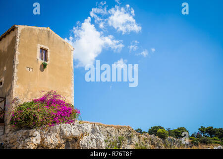 Sizilien, Italien. Altes Haus mit lila Blüten in Syrakus. Stockfoto