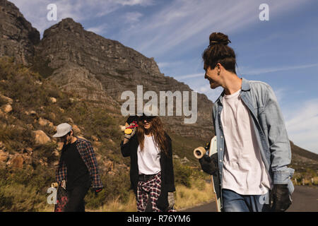 Skateboarder wandern mit Skateboard an Land Stockfoto