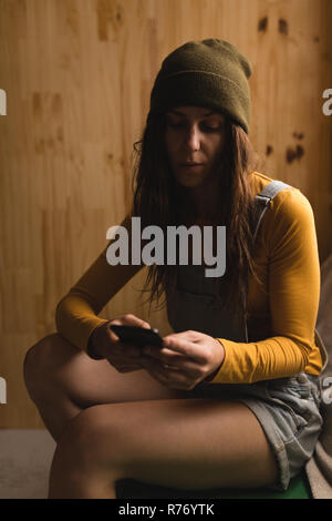 Frau mit Handy in der Werkstatt Stockfoto