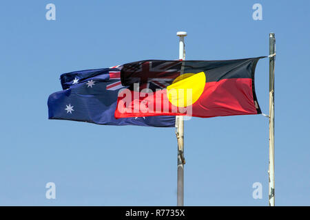 Australische Aborigines Flaggen im Wind, mit Union Jack durch die darüber liegende Aboriginal Flagge sichtbar Stockfoto